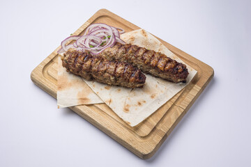 Delicious Lyulya kebab on a wooden board. Close-up 