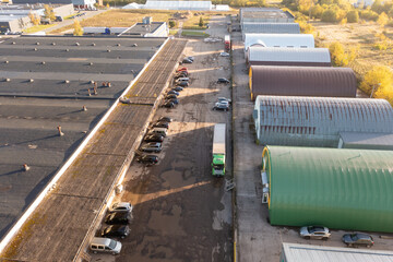 Drone photography of large warehouse complex with parked lorry's during autumn day
