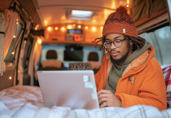 A young man is working on a laptop in his travel car. Concept - remote work. 