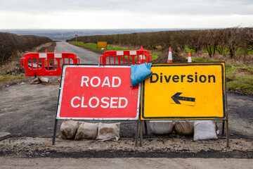 Road Closed and Diversion Signs with red barriers and traffic cones on a rural road in the Yorkshire Wolds, East Yorkshire, Winter 2024.   Horizontal.  Space for copy.