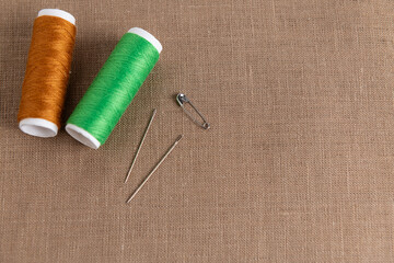 Sewing background, threads and needles on natural linen fabric - 733417360