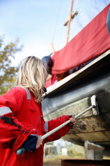 Close-up of a young woman cleaning her boat in a marina, Holland