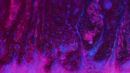 Glitter paint texture. Oil fluid flow. Defocused magenta pink blue color sparkling texture liquid...