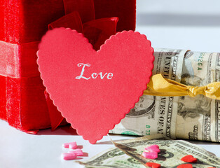 The cost of love. Red hearts and boxes wrapped in cash illustrate the high cost of Valentine's day and love in general