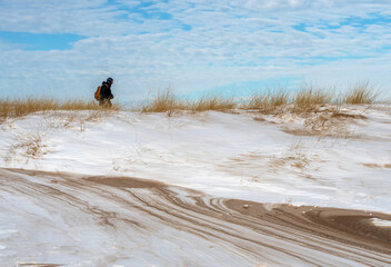 Back packer Walking on a frozen beach on the shores of Lake Michigan USA