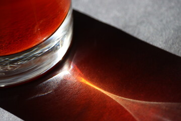 sun light refraction from glass of red tea