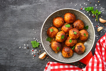 Meatballs in tomato sauce with herbs in frying pan. Top view with copy space.