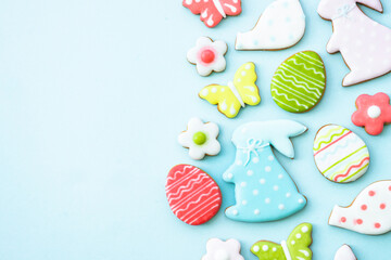 Easter gingerbread cookies on blue, Colored eggs, rabbit, flowers and others. Flat lay with copy...