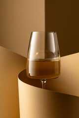Glass of white wine on a beige background.