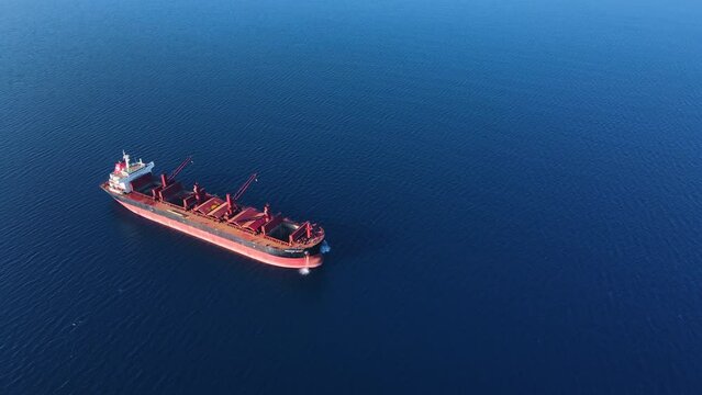 Dry bulk cargo carrier ship anchored washing ship holds preparing for loading new dry cargo, aerial view