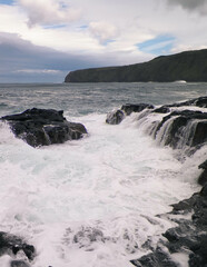 Waves crashing against rocks. Piscinas Naturais Caneiros Natural Park.