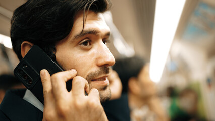 Closeup image of skilled business man face phone call to project manager in train with blurred...