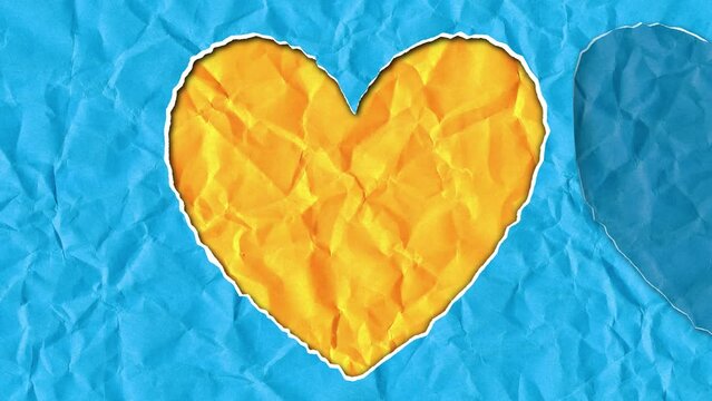 Scrap of paper in the shape of a heart in the colors of the Ukrainian flag