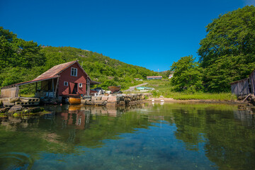 Fototapeta na wymiar Old boat house and a small beach at summer.