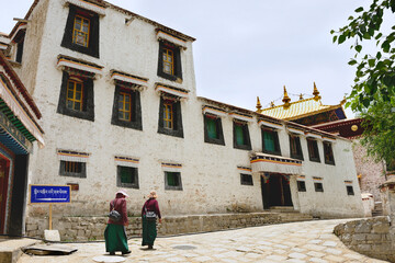 Two woman walk down a cobblestone street at Sera Monastery, located just outside Lhasa, Tibet...