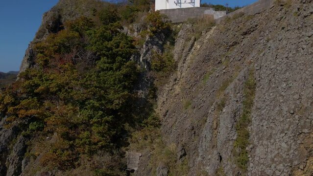 Cinematic aerial shot of lighthouse at Cape Chikyu in Muroran City in Hokkaido, Japan