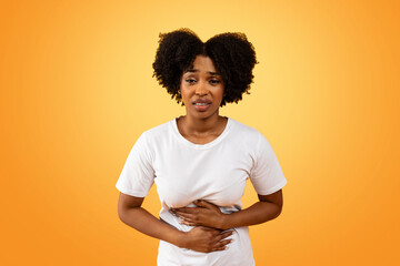African american woman with abdominal pain in white t-shirt