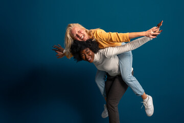 Interracial best friends laughing and having a good time together in a studio. Ecstatic young woman...
