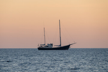A sail boat alone at sea, at sunset. High quality photo