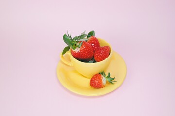 strawberries in a yellow tea cup 