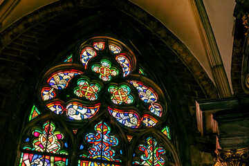 Beautiful colorful old antique stained glass window inside a church, cathedral, multi colored stained glass art up close, nobody, light shining through. Religious art