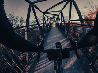 Riding a tourism bicycle crossing a pedestrian bridge rider point of view