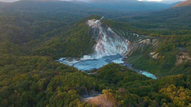 Cinematic aerial shot of geothermal steam vents in Jigokudani Hell Valley in Noboribetsu city in Hokkaido, Japan