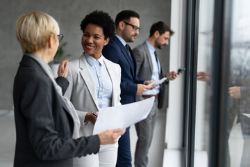Image of group of business people standing near windows