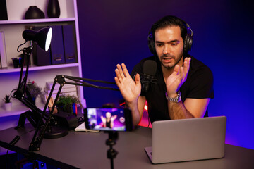 Broadcaster talking to listener on live streaming online, recording by smartphone setting on social...