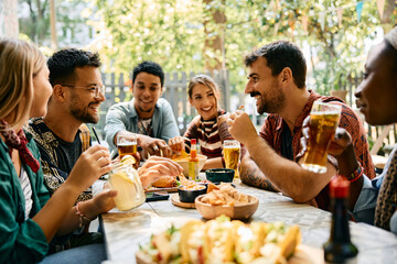 Fototapeta na wymiar Happy men and their friends enjoying in food and drinks in restaurant.