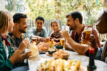 Foto op Aluminium Happy men and their friends enjoying in food and drinks in restaurant. © Drazen