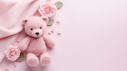Obraz premium A small knitted amigurumi bear toy on a pink blanket, on a pink background. Flat lay, top view, copy space. space for text