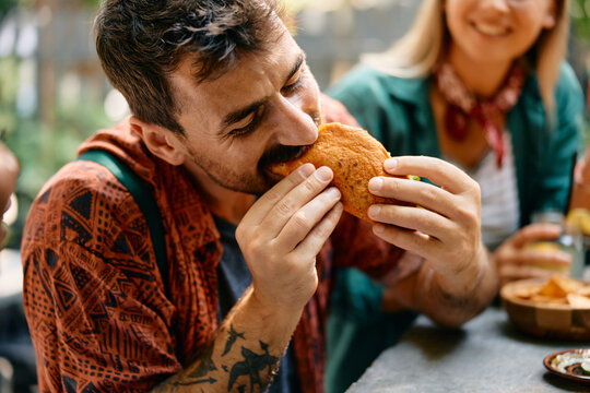 Young man eating tacos at Mexican restaurant.