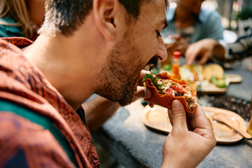 Close up of man an biting taco during lunch in Mexican restaurant.