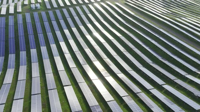 Drone shot flying backwards over never ending field of solar panels. HDR ProRes aerial video of solar farm in Puerto Rico.