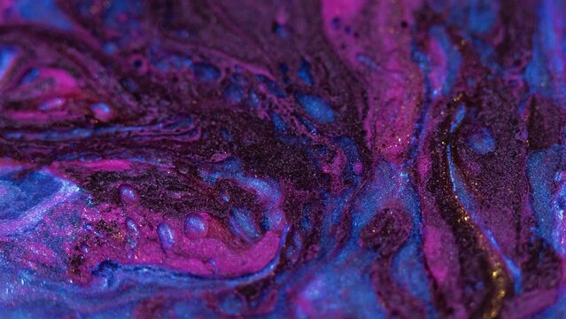 Glitter paint bubbles. Oil fluid flow. Defocused purple blue color sparkling texture liquid ink water emulsion mix motion abstract art background.