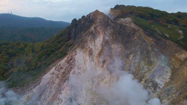 Cinematic aerial shot of geothermal steam vents in Jigokudani Hell Valley in Noboribetsu city in Hokkaido, Japan