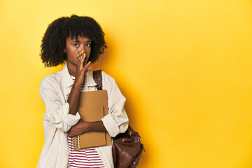 Studious teen girl with backpack and notebooks, yellow backdrop is saying a secret hot braking news...