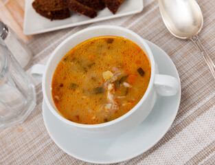 Portion of fresh russian soup rassolnik served on plate in eatery.