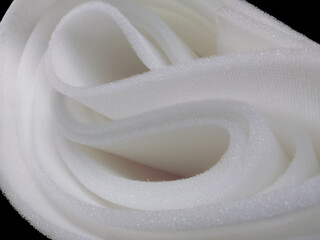 one roll of white sponge foam material on black background