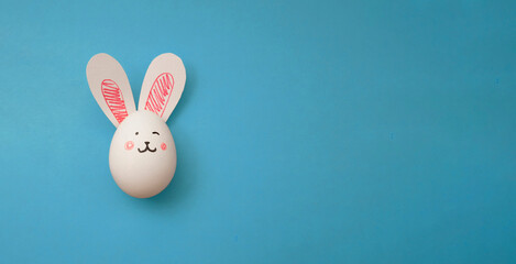 Easter Bunny. Horizontal banner with copyspace for text. White chicken egg with pink rabbit paper...