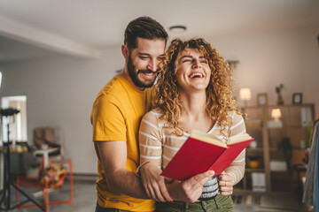 portrait of man and woman caucasian adult couple with book at home