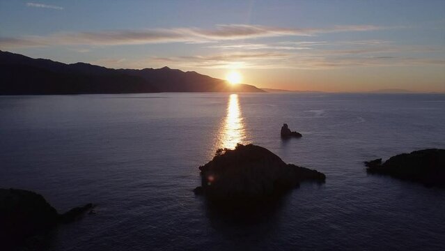 This footage was made with a drone at Euboea Island, with a few small silhouettes of islands in a frame, at sunset, and a lot of birds flying arround