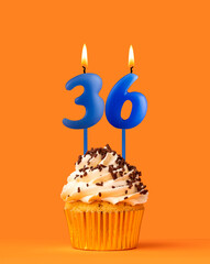 Blue candle number 36 - Birthday cupcake on orange background