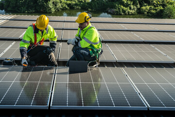 Worker Technicians are working to construct solar panels system on roof. Installing solar photovoltaic panel system. Men technicians carrying photovoltaic solar modules on roof.