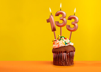 Number 133 birthday candle - Celebration on yellow background