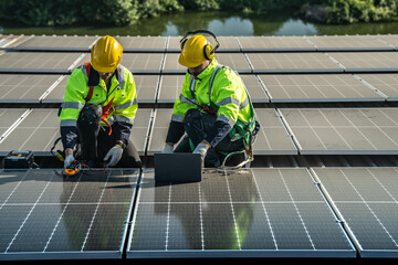 Worker Technicians are working to construct solar panels system on roof. Installing solar photovoltaic panel system. Men technicians carrying photovoltaic solar modules on roof.