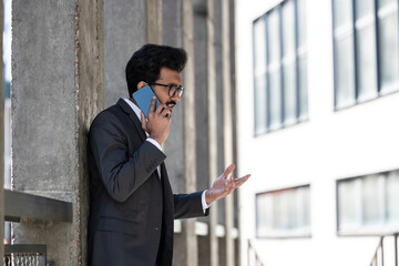 Young businessman having a phone conversation and looking excited