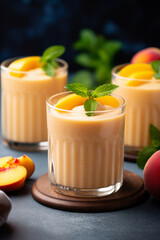 Peach smoothie in tall glasses on dark wooden table