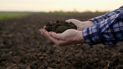 Agricultural industry. Farmer hands hold fertile soil, natural fertilizer, compost. Farmer checks composition of soil before sowing. Man, woman holding land in hands in close-up. Concept agriculture